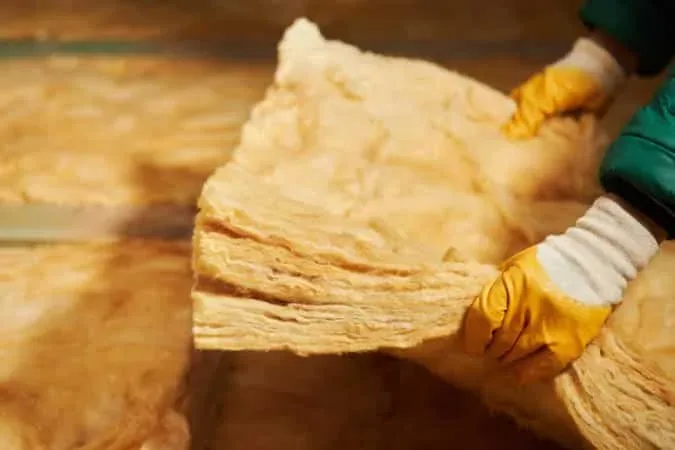 Pose de laine de verre pour isolation de combles