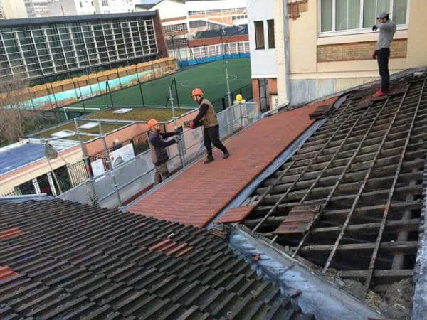 Dépose de l'ancienne couverture et pose des tuiles mécaniques neuves lors d'une rénovation de toiture par PS Rénovation
