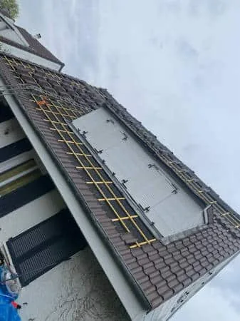 Zone de toiture en cours de reprise avec liteaunage et écran posés autour d'un chien-assis