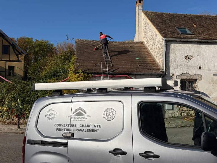 Un Véhicule de M. Paumard Stanley staionné devant une toiture entrain dêtre nettoyée par un couvreur
